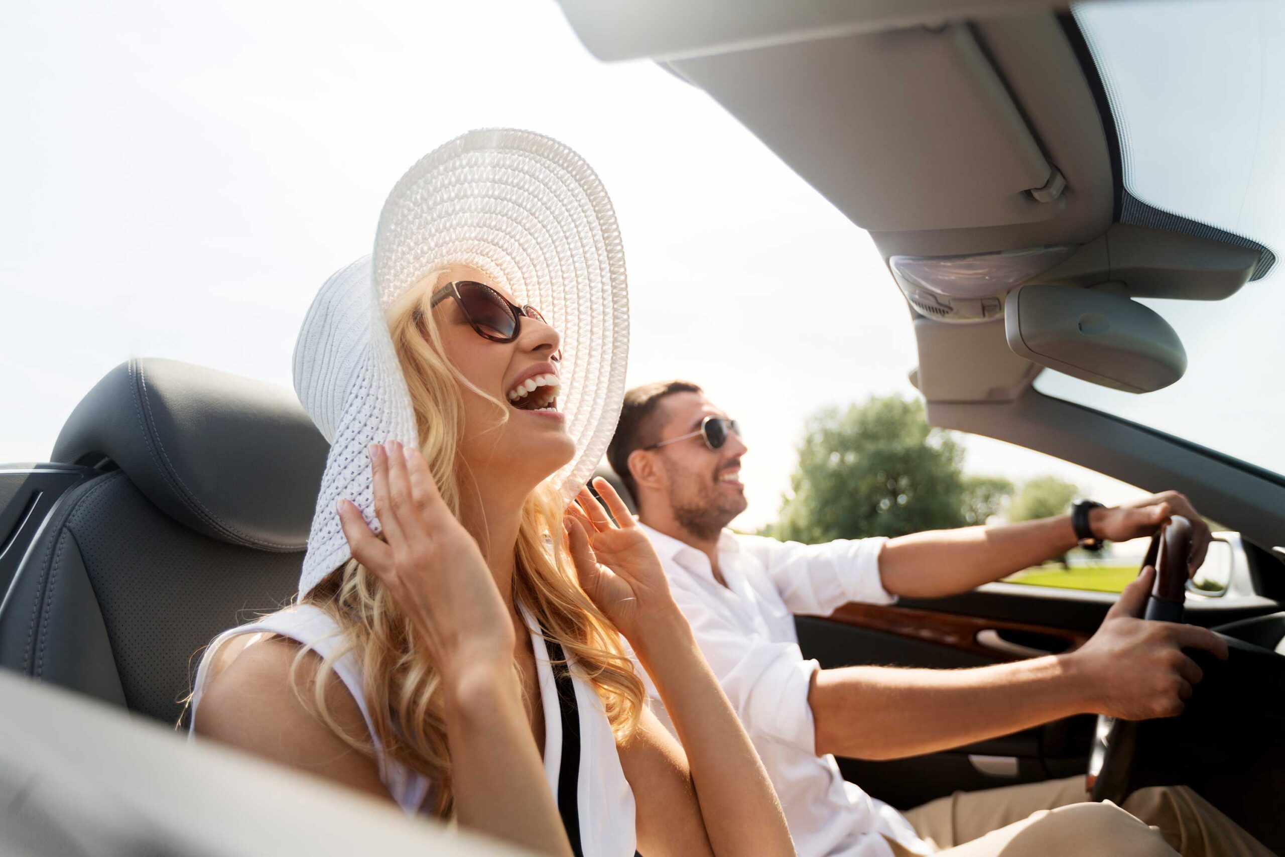Happy couple driving a convertible car
